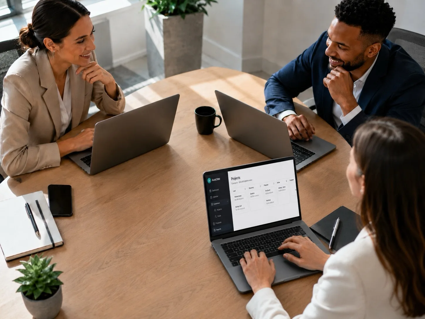 Advisors collaborating around a table with AdviseCRM projects open on a laptop